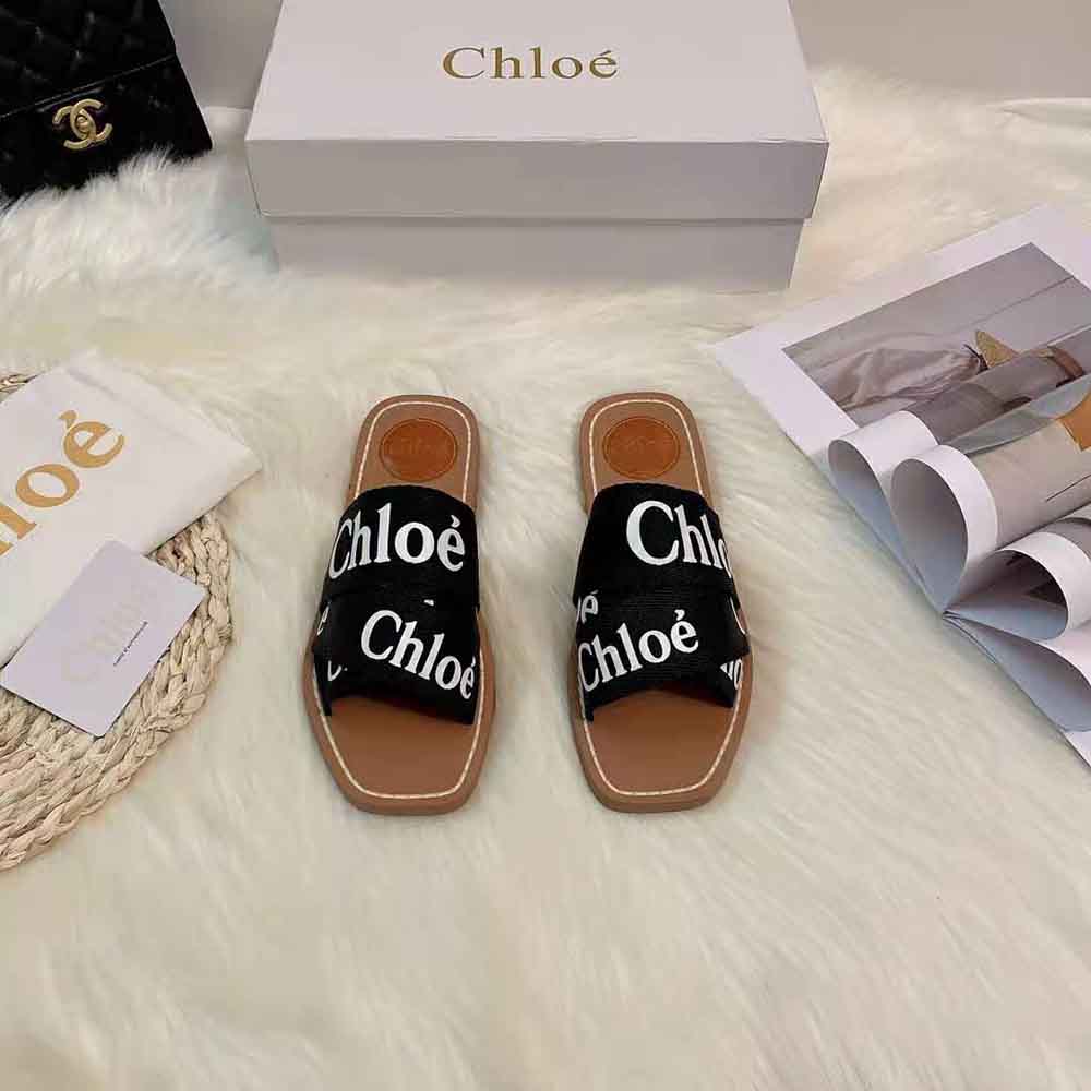 Close-up on wooden sole detail of Chloe Women Woody Flat Mule black canvas
