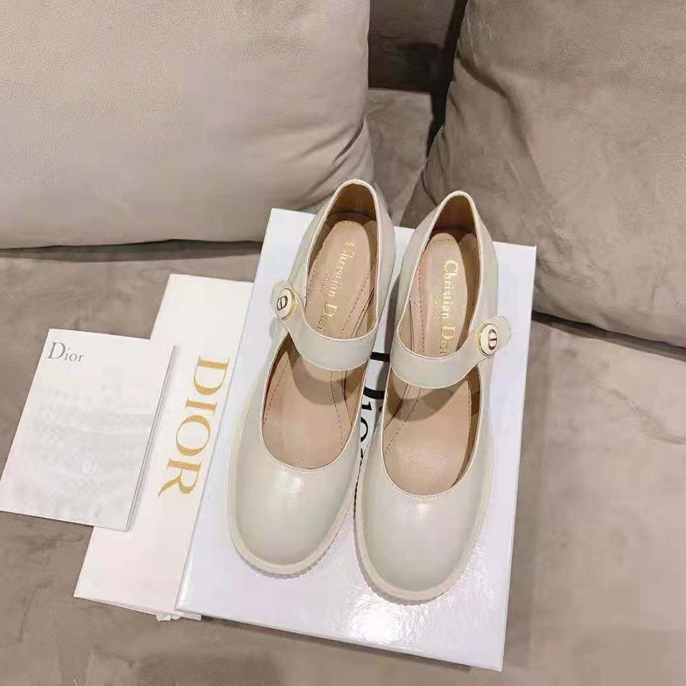 Close-up on Dior signature hardware of white shiny calfskin pump