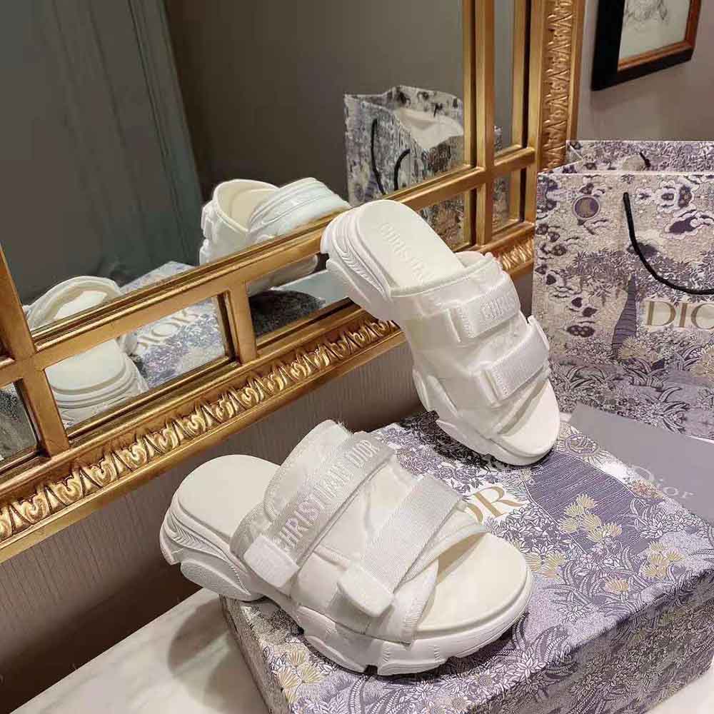 Close-up of Dior logo hardware on white camouflage slide sandal