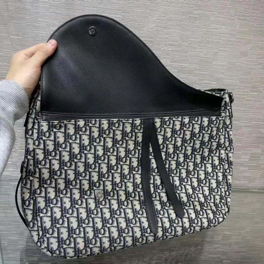 Close-up of silver ‘D’ charm on Dior Women Saddle Soft Bag