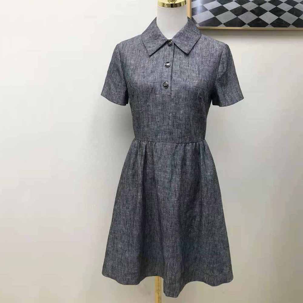 Close-up of blue-gray fabric and Dior signature detail on dress