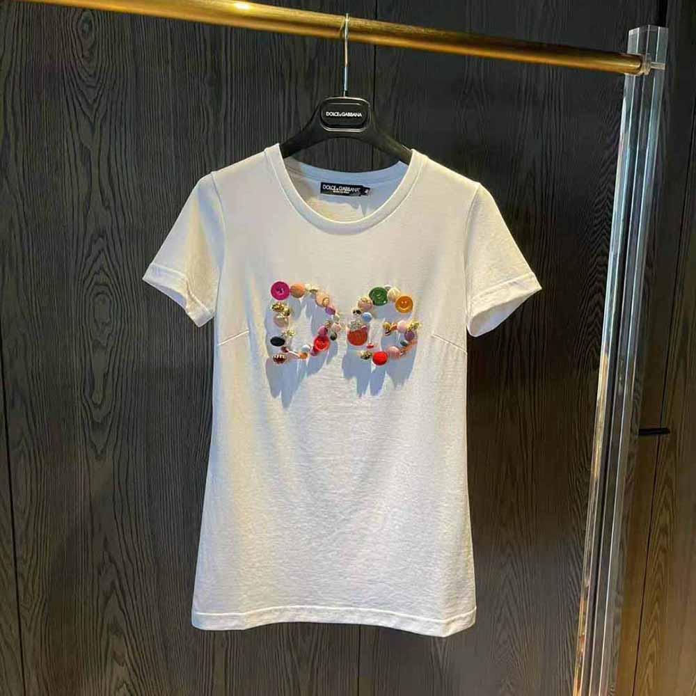 Close-up of DG button embellishment on white Dolce Gabbana D&G t-shirt