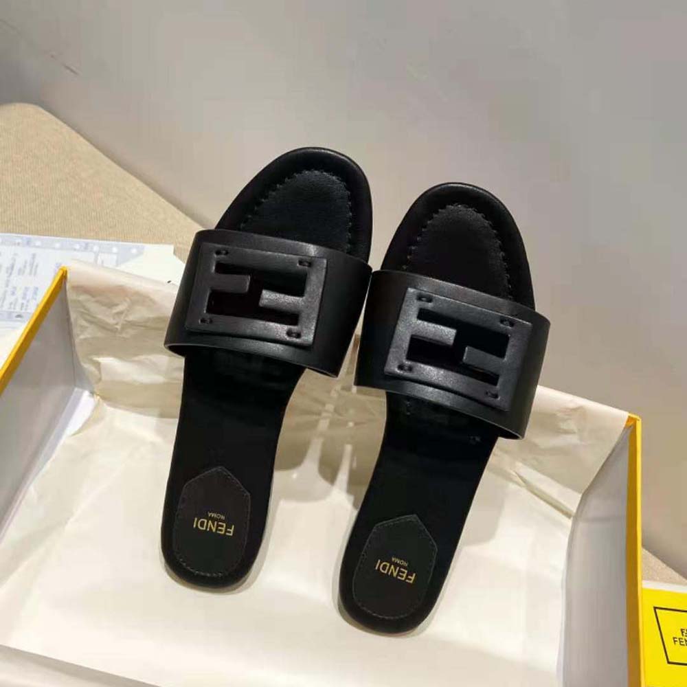 Close-up of embossed Fendi logo on black leather slides