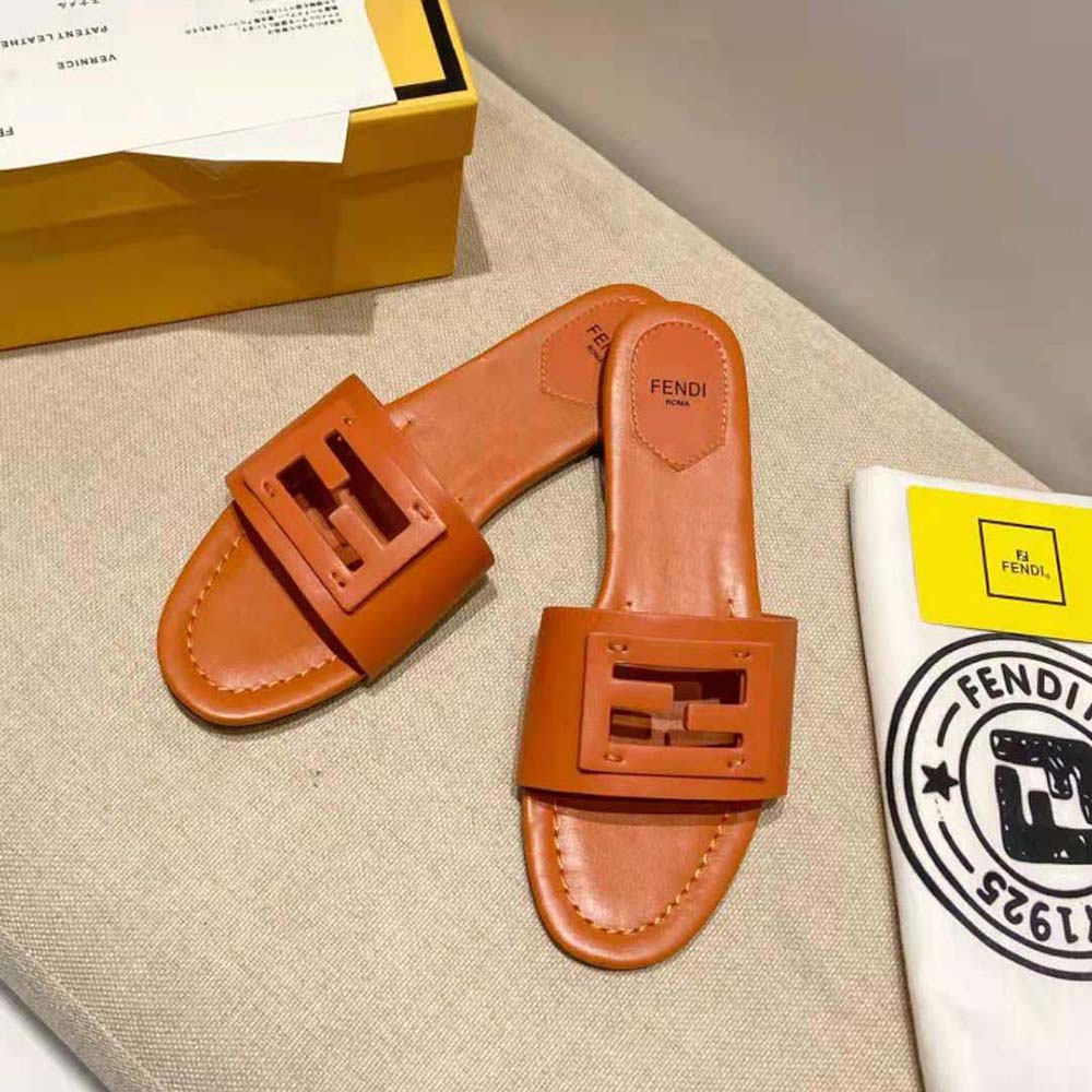 Close-up of Fendi signature logo detail on brown leather slides