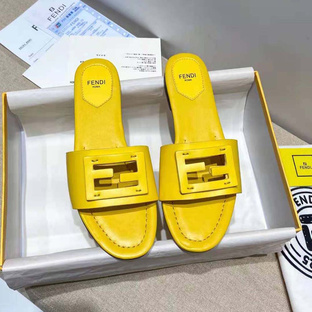 Close-up of embossed Fendi signature detail on yellow leather slide