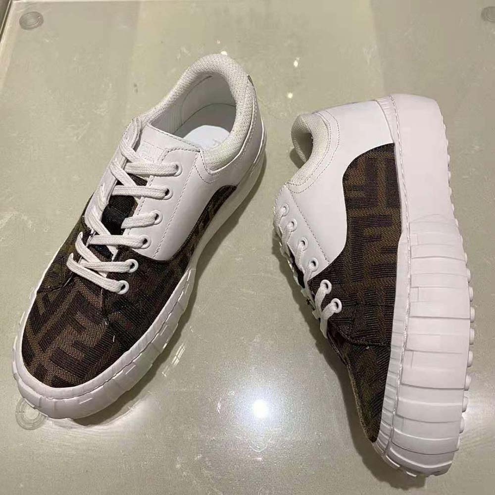 Close-up of lace-up detail and Fendi logo hardware on sneakers