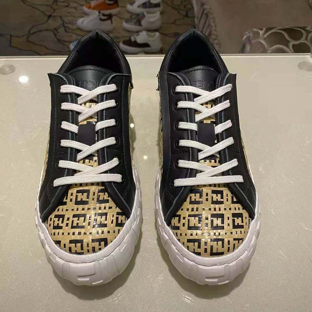 Close-up of Fendi logo hardware on beige raffia low-top sneaker