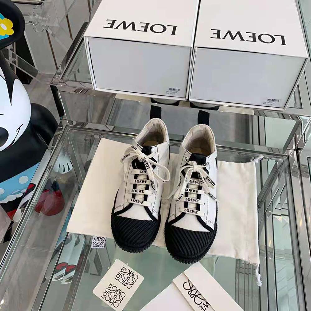 Close-up of white canvas and embossed Loewe logo on high top sneaker
