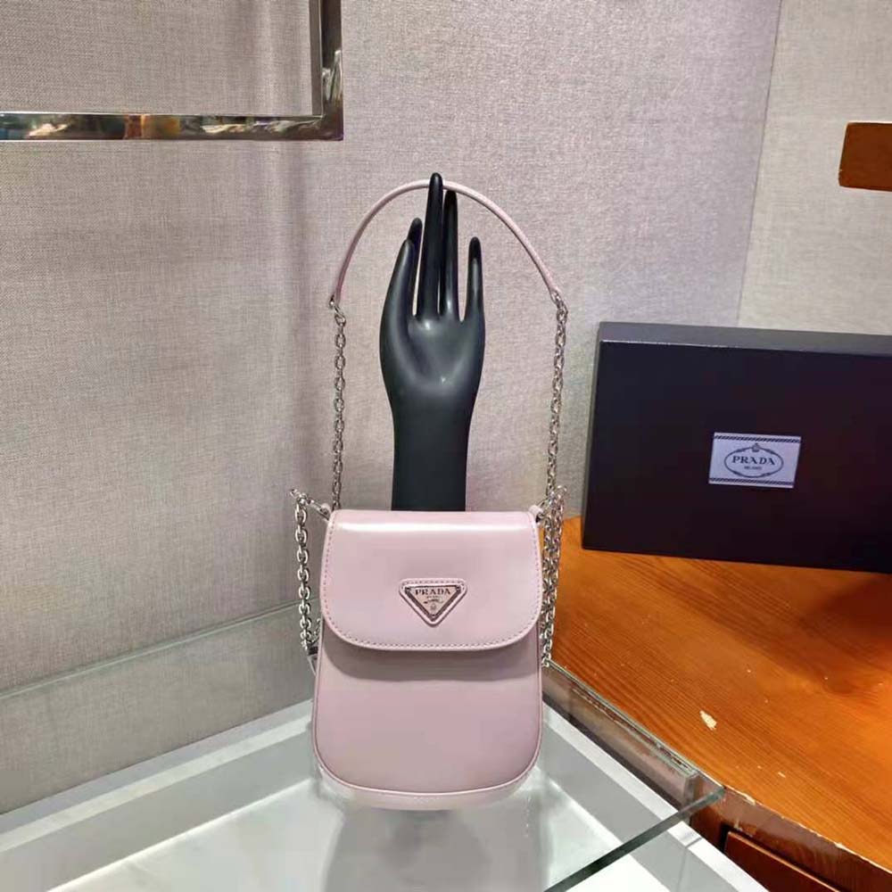 Close-up of Prada logo hardware on pink brushed leather mini-bag