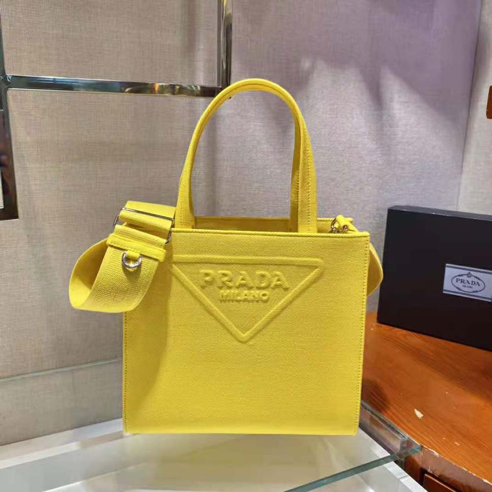 Close-up of Prada logo and silver hardware on yellow drill tote bag