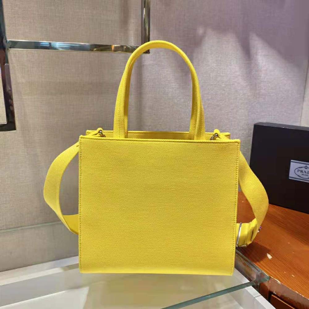 Side angle highlighting leather handles and structured silhouette of Prada tote