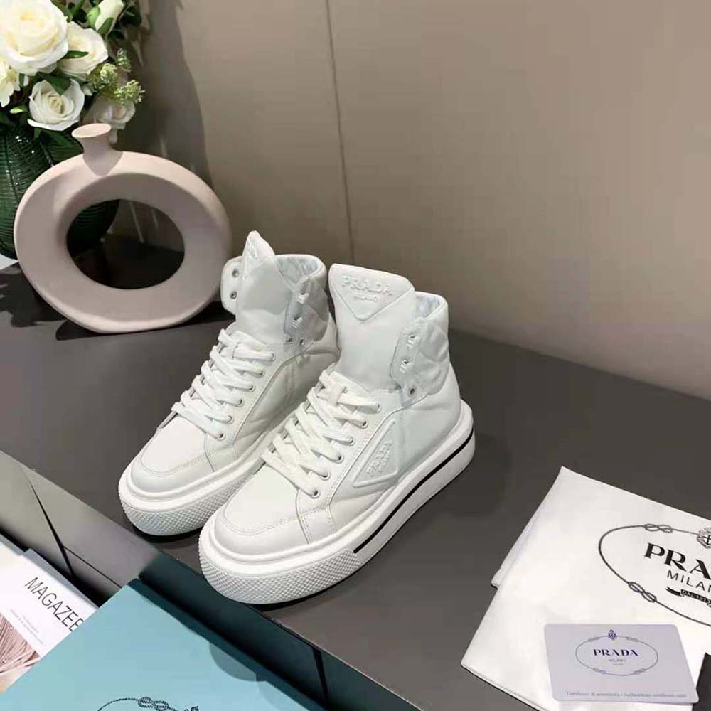 Close-up on brushed leather and Prada logo hardware on high-top sneaker