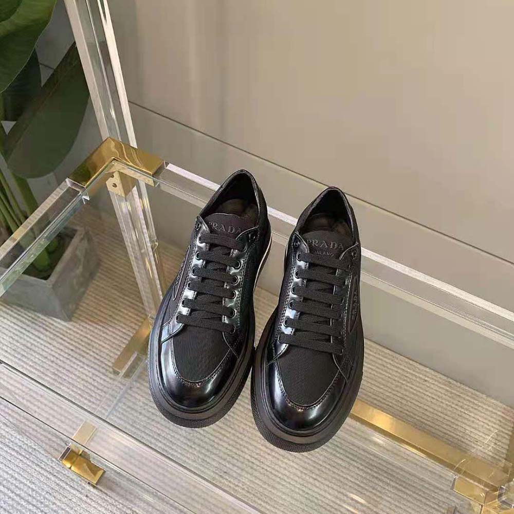 Close-up on brushed leather detail and Prada logo on sneakers