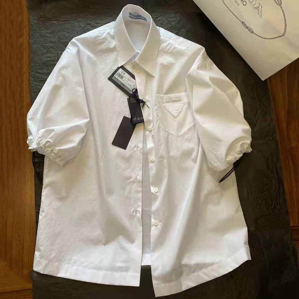 Close-up of Prada blouse white poplin fabric and button closure detail