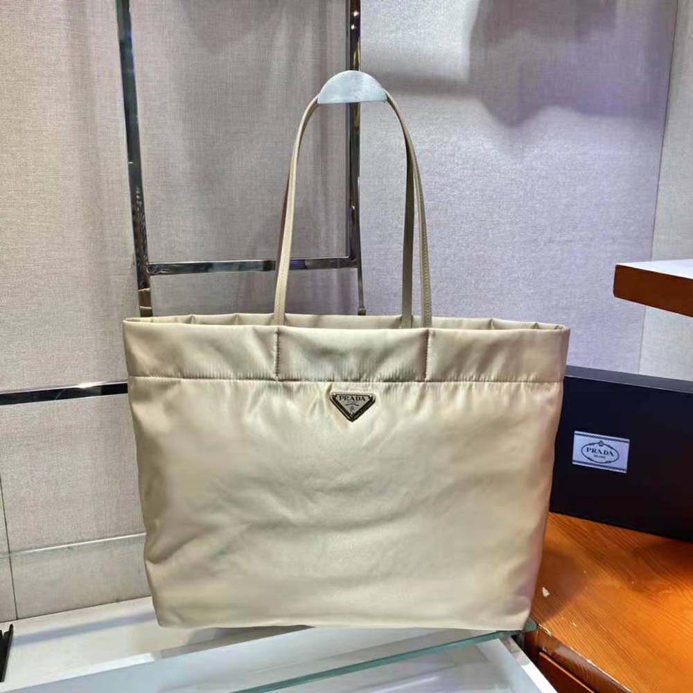 Close-up of saffiano leather texture and Prada logo on beige tote bag