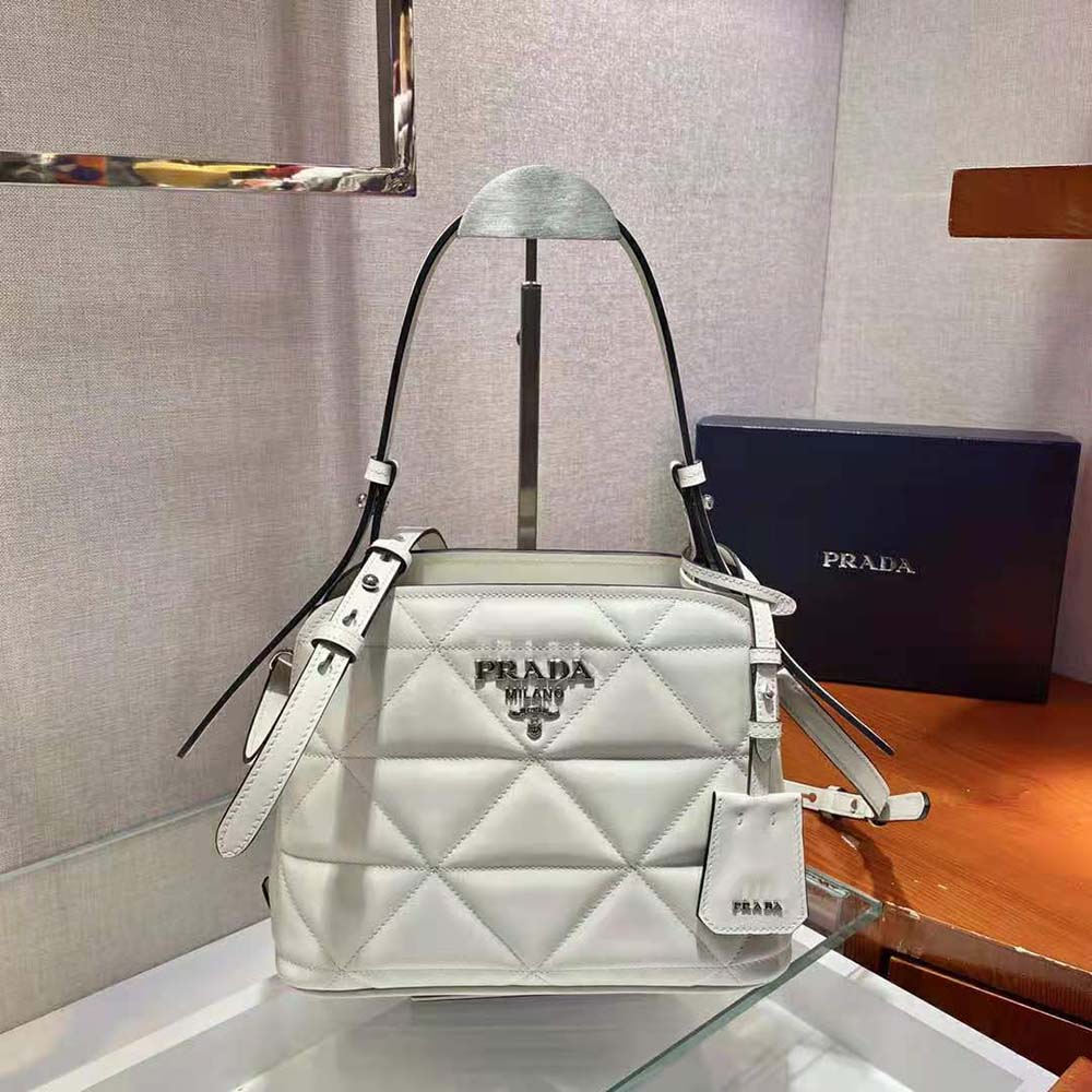 Close-up of silver hardware and smooth white leather on Prada bag