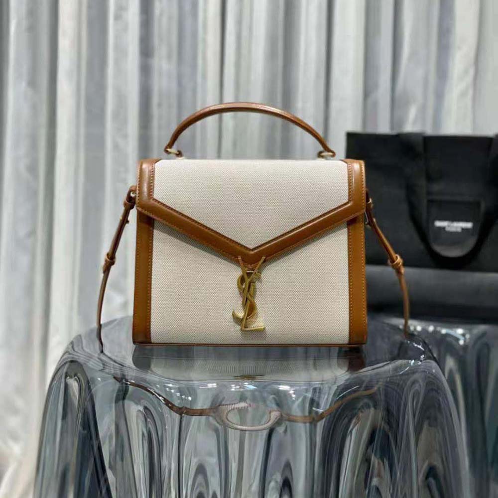 Close-up of gold YSL logo hardware on Cassandra Medium Top Handle Bag