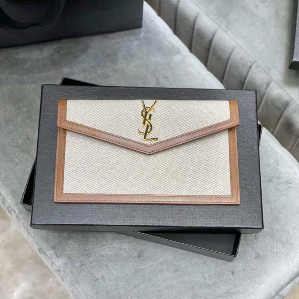 Close-up of gold YSL logo hardware on Uptown Pouch in brown