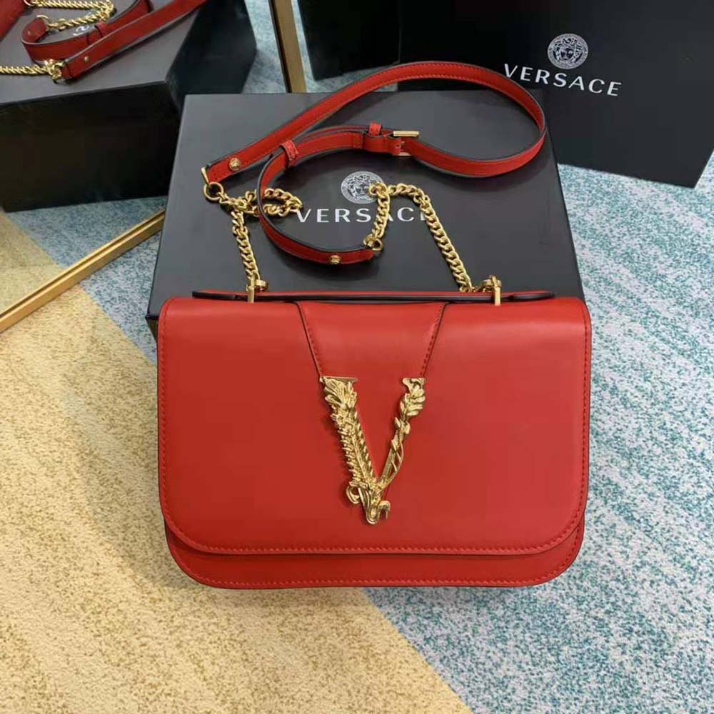 Close-up detail of red leather and polished gold hardware on Versace bag