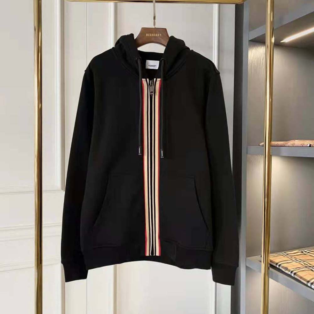 Close-up of Burberry signature stripe detailing on black hooded top
