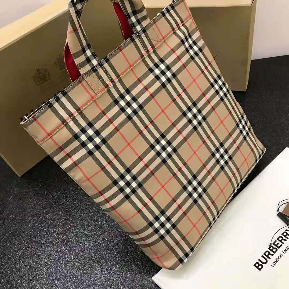 Side view showing brown leather straps on Burberry cotton blend tote