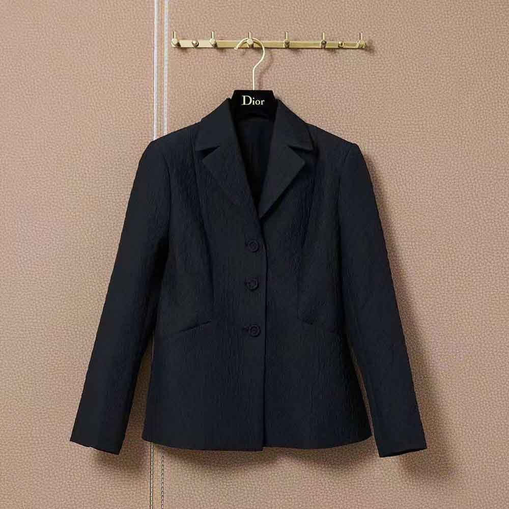 Close-up of black matte buttons and textured fabric on Dior jacket
