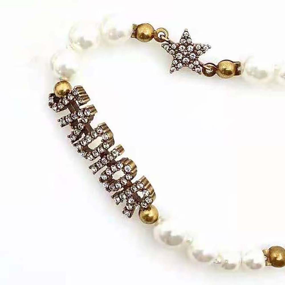 Styled shot of Dior Women J’Adior Choker Necklace against black fabric background