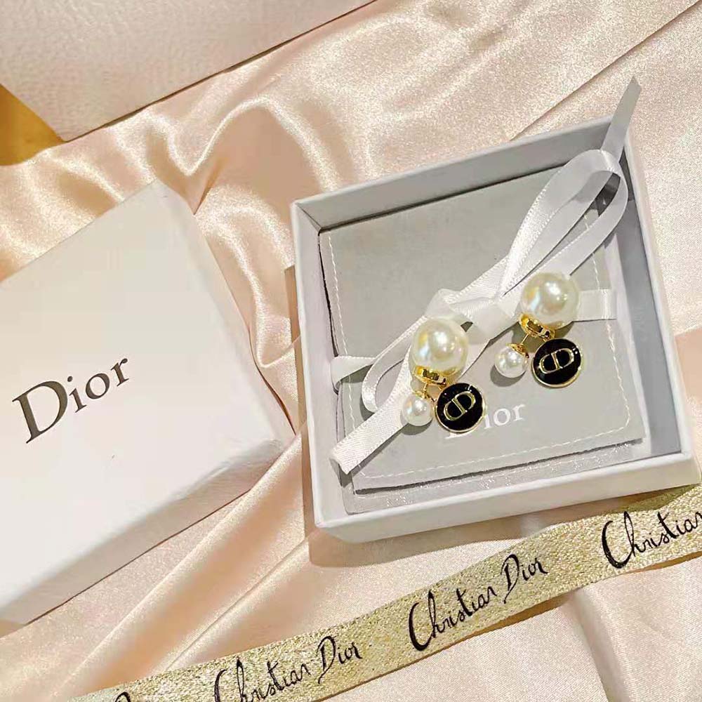Close-up on white resin pearl and black lacquer detail of Dior Women Tribales earrings