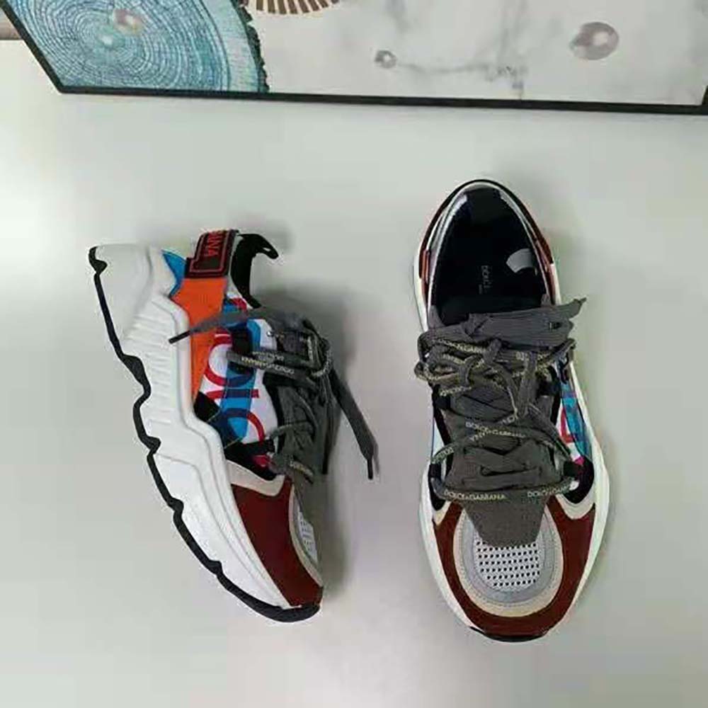 Close-up of signature D&G logo hardware on orange Daymaster Sneakers