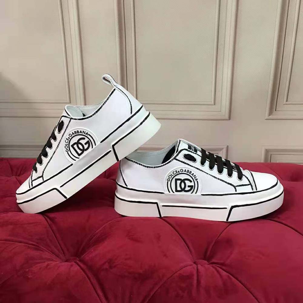 Close-up detail of hand-painted canvas and D&G embossed hardware on the sneakers