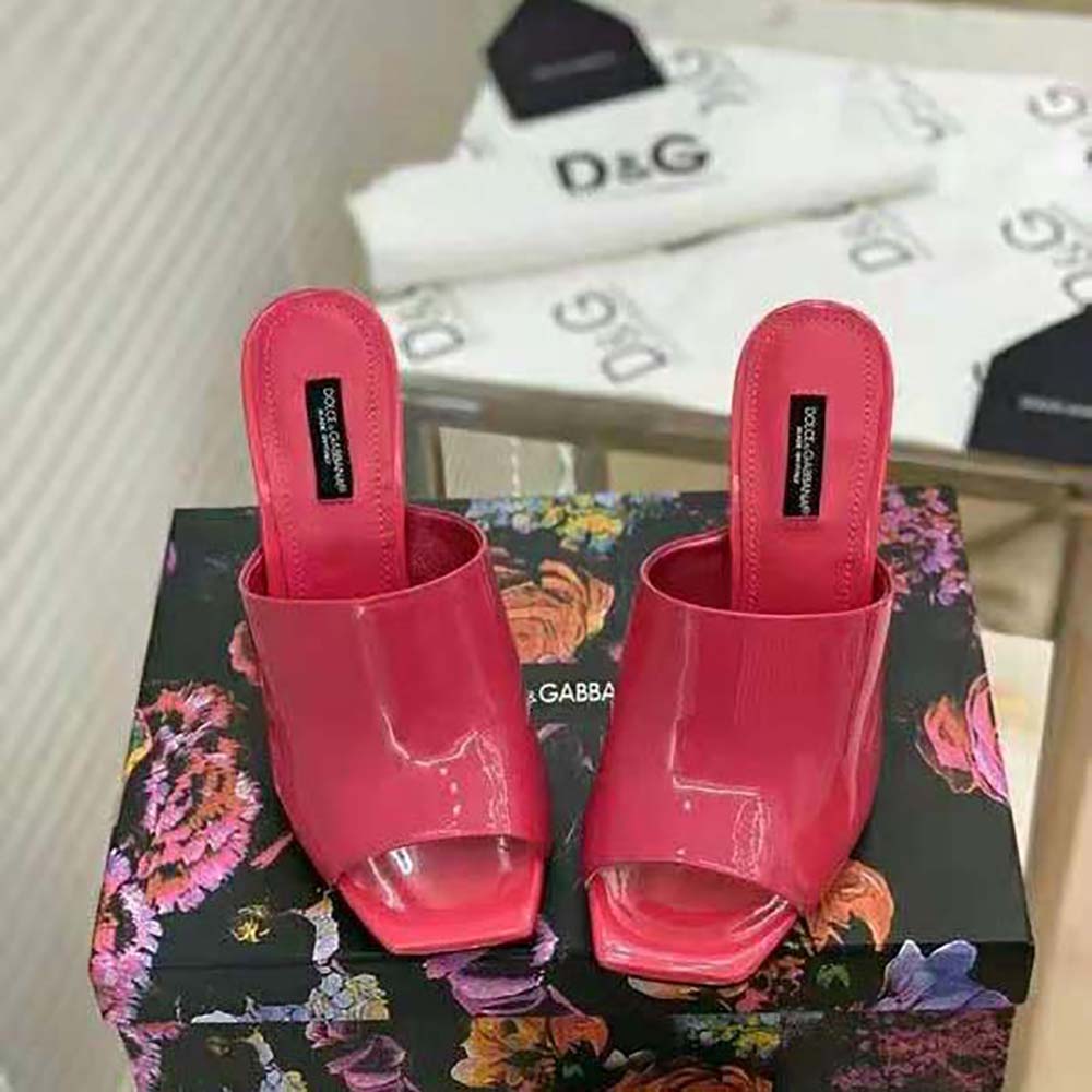 Close-up of pink patent leather and DG pop logo heel on mules