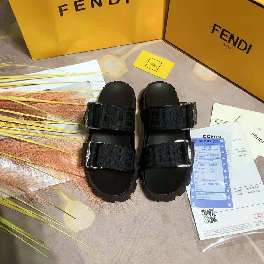 Close-up of black fabric and signature Fendi hardware on sandals