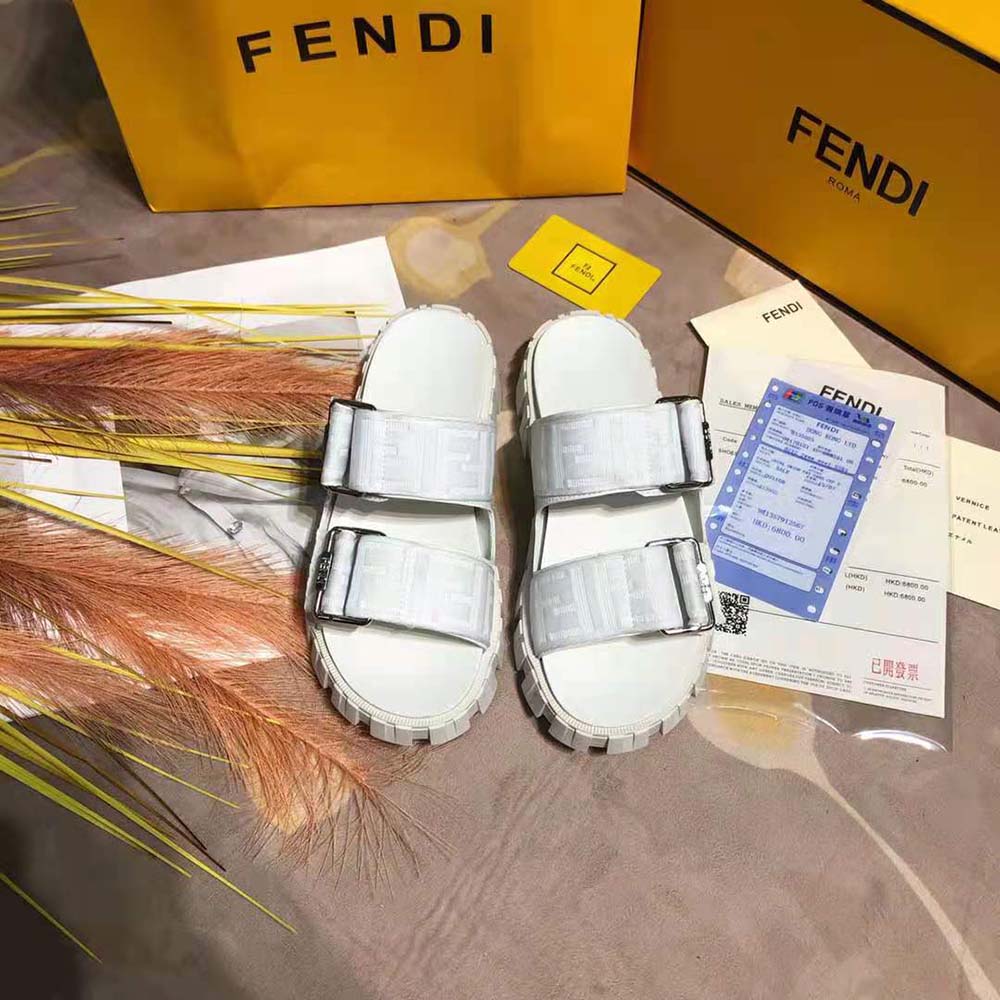 Close-up of Fendi logo hardware detail on white fabric sandal