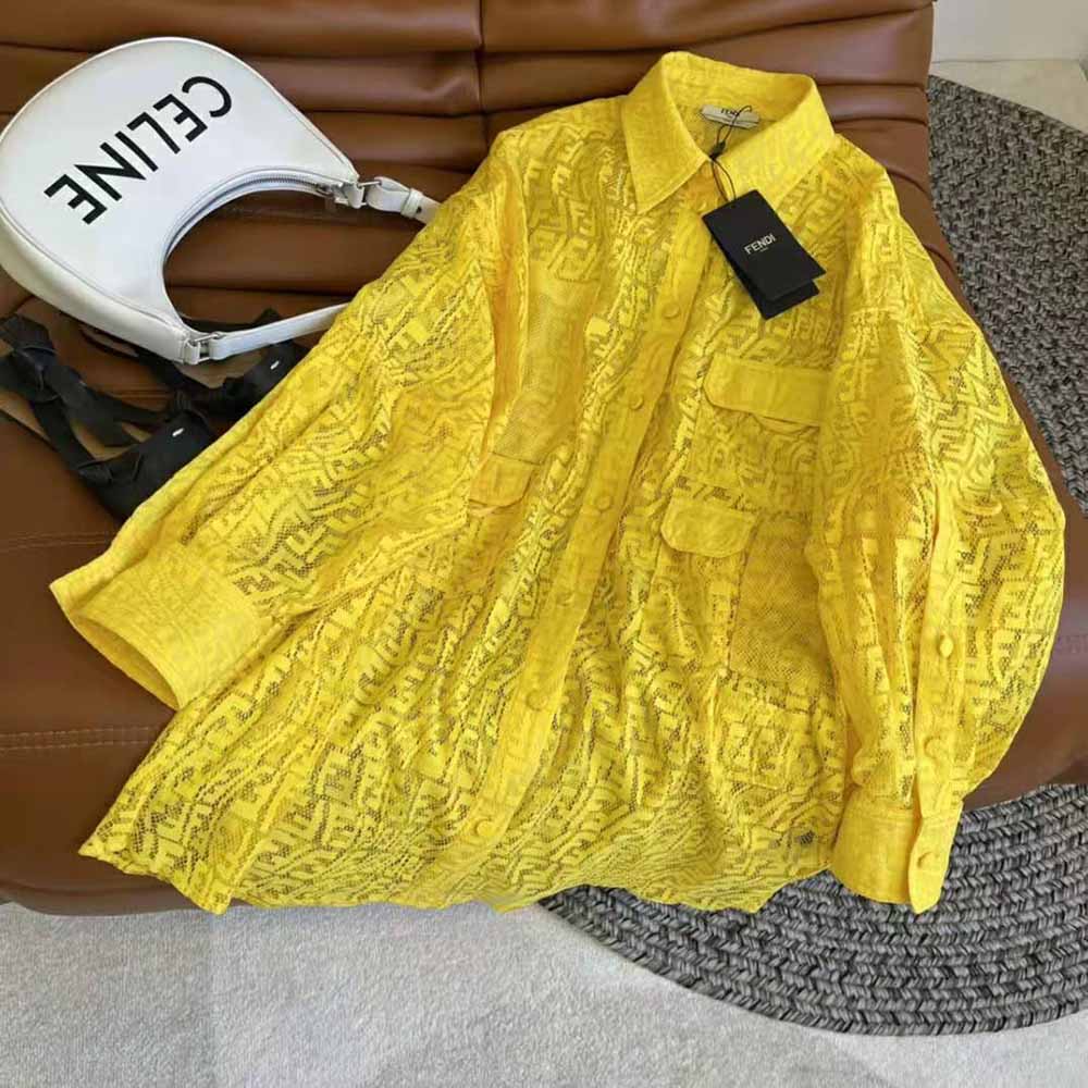 Close-up of Fendi logo buttons and delicate lace on oversized shirt dress