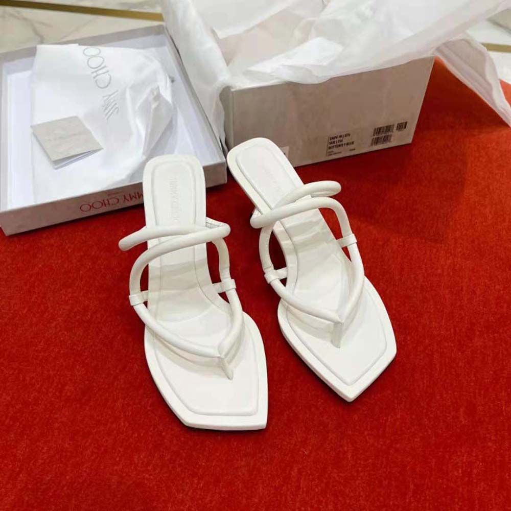 Close-up detail of white nappa leather and gold hardware on Jimmy Choo mules
