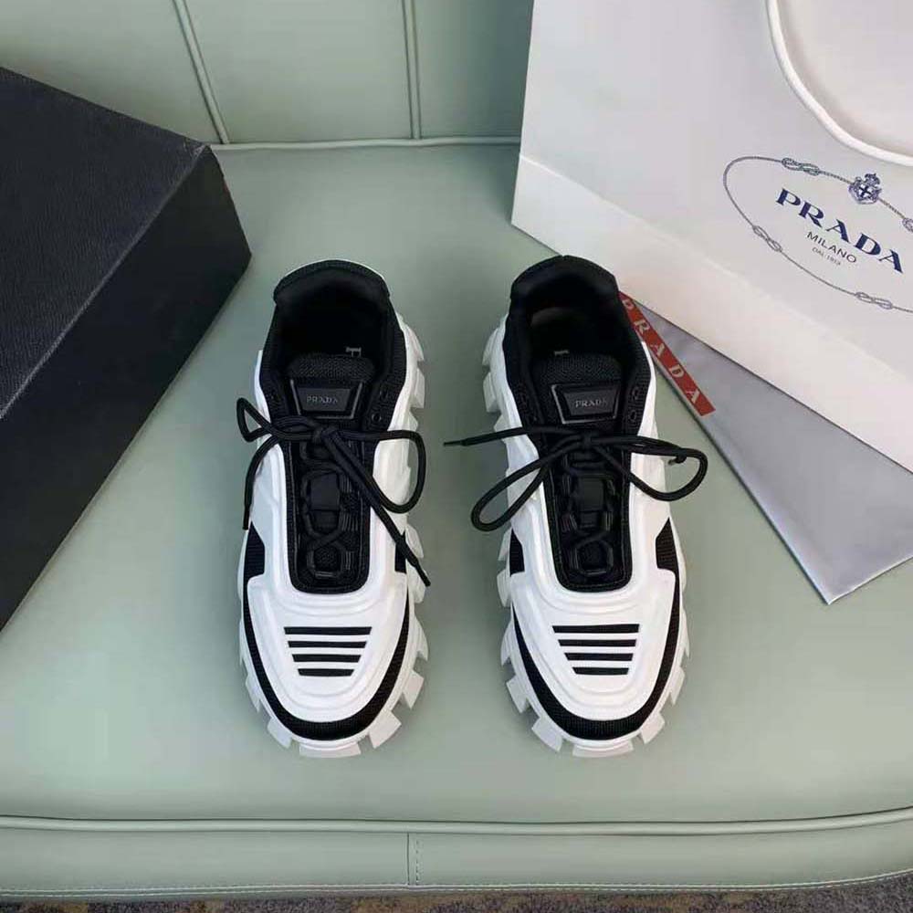 Close-up on Prada logo plaque detail on Cloudbust Thunder Sneakers-Black