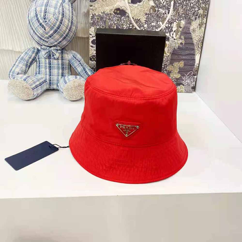 Close-up detail of red nylon and Prada triangle logo on bucket hat