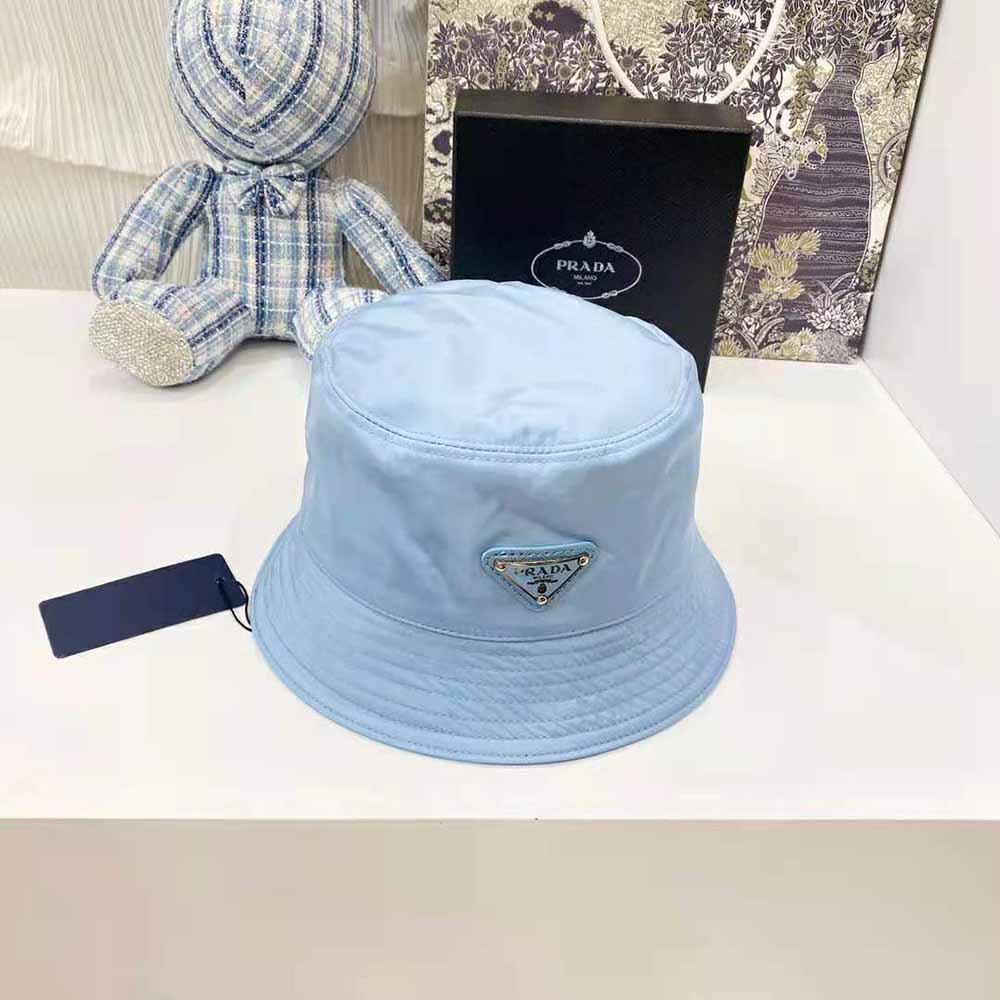 Close-up of blue nylon texture and metal triangle logo on Prada bucket hat