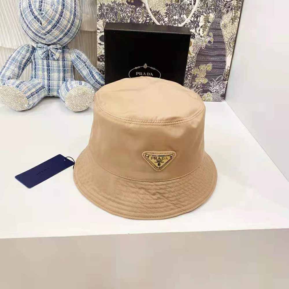 Close-up of Prada triangle logo on sandy nylon bucket hat