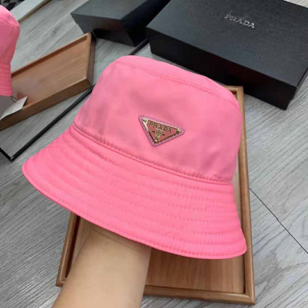 Close-up of triangular Prada logo on pink nylon bucket hat