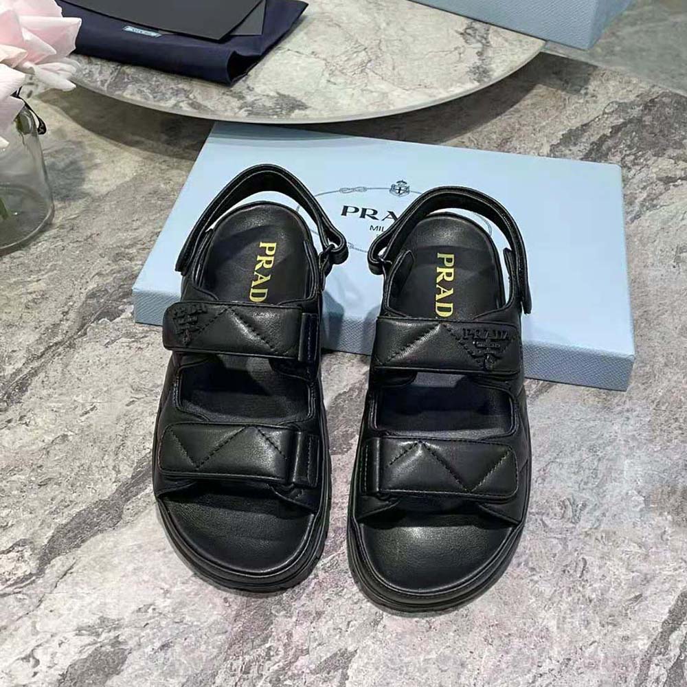 Close-up of black nappa leather and Prada embossed logo on sandals