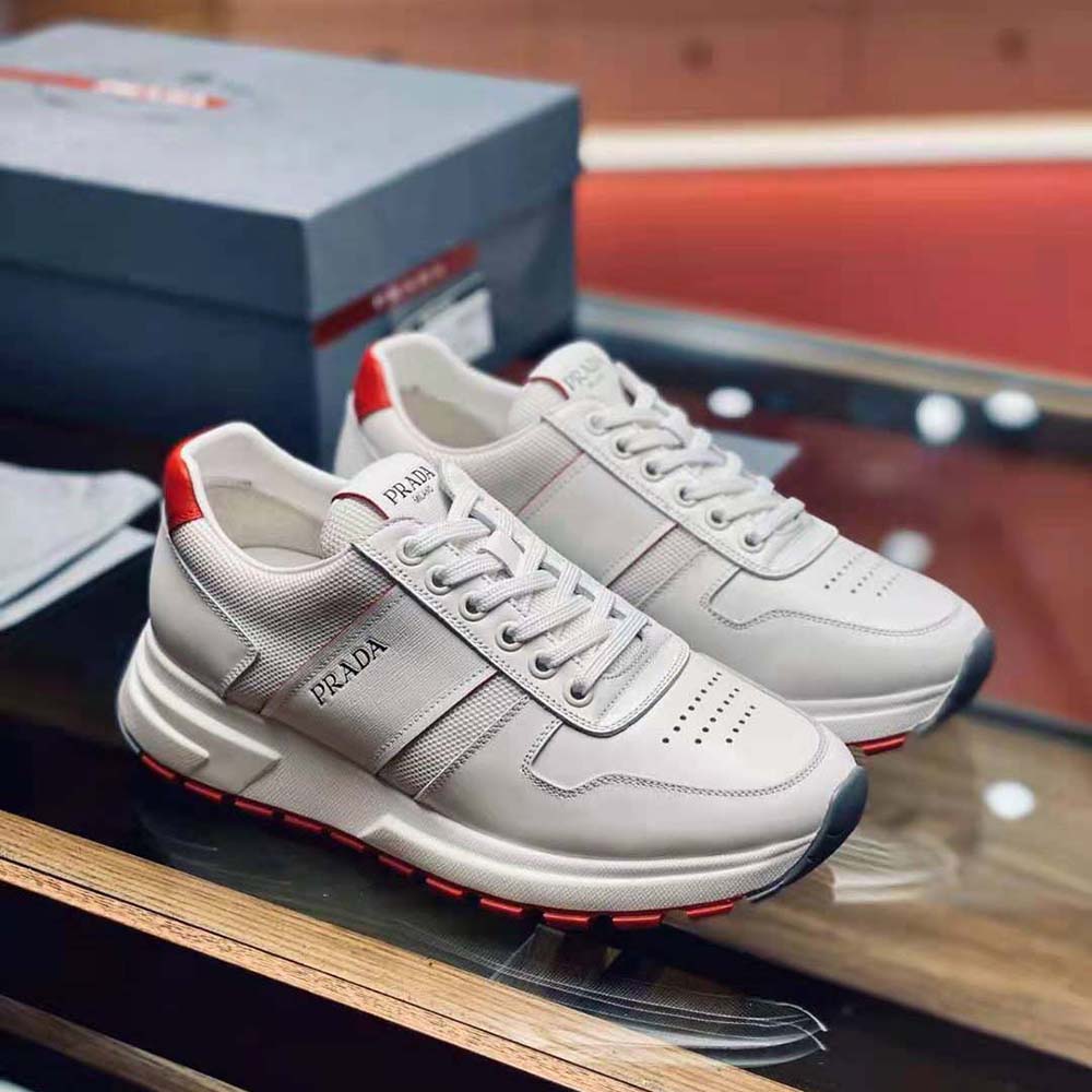 Close-up of Prada logo hardware on white sneakers' lace area