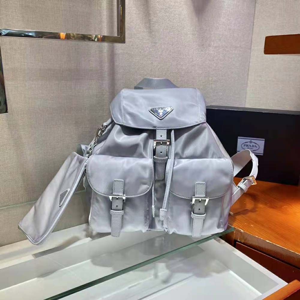 Close-up of silver-tone Prada logo and hardware on Re-Nylon navy backpack