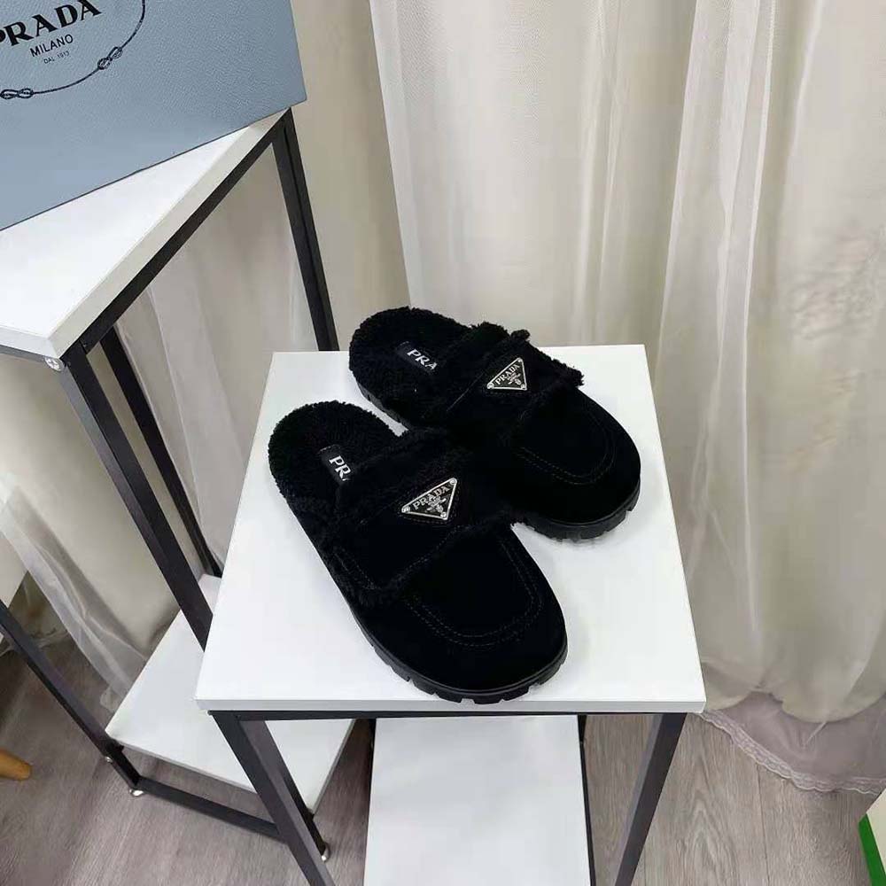 Close-up of enameled metal triangle logo on Prada Women Shearling Slippers