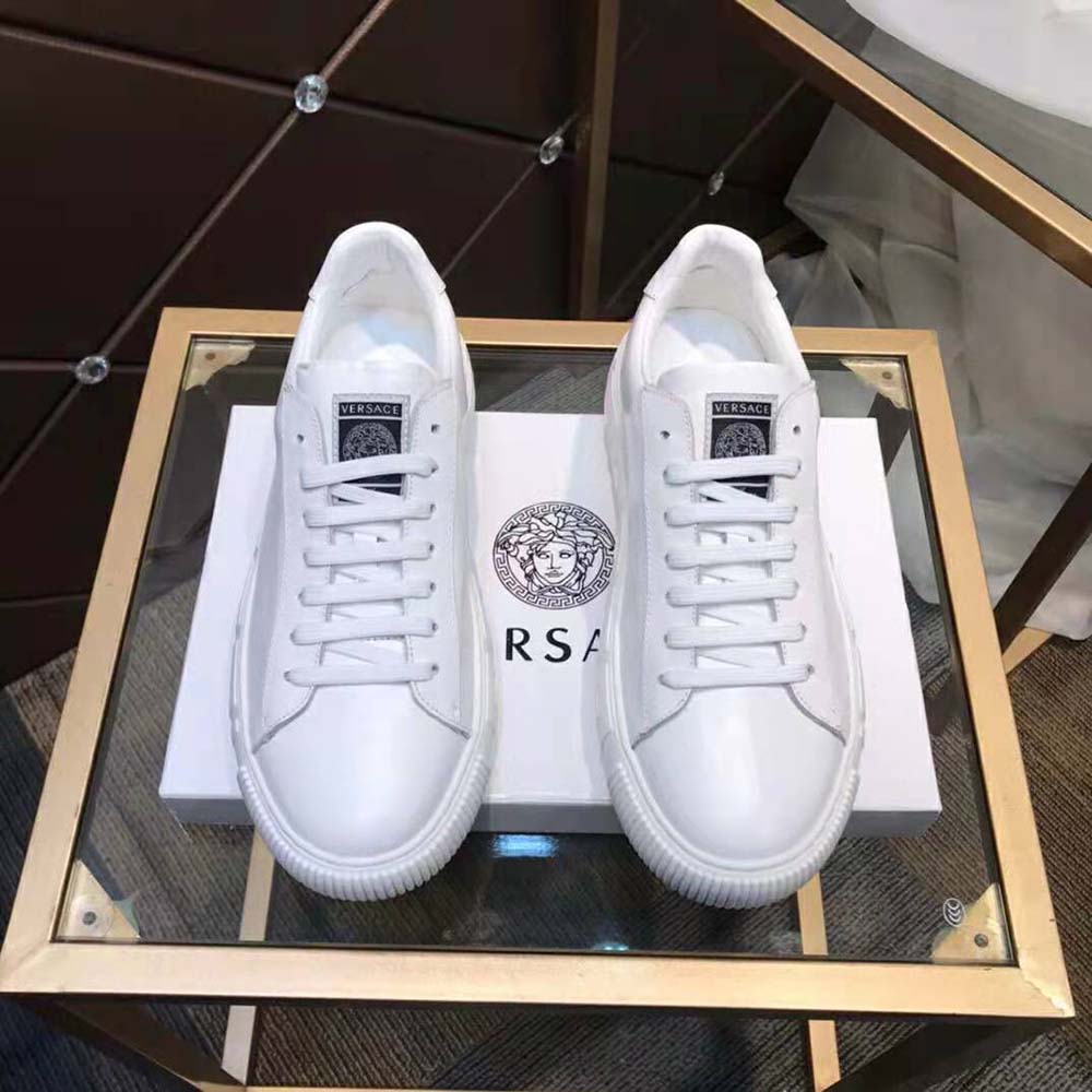 Close-up of gold Greca emblem on Versace Women A Classic Low Top Greca Sneakers-White