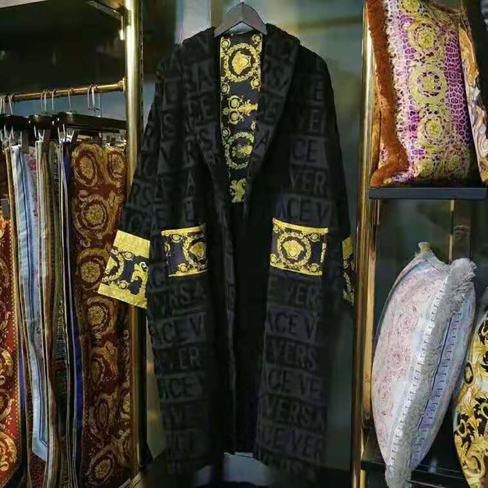 Close-up of Versace Medusa hardware on black Baroque bathrobe