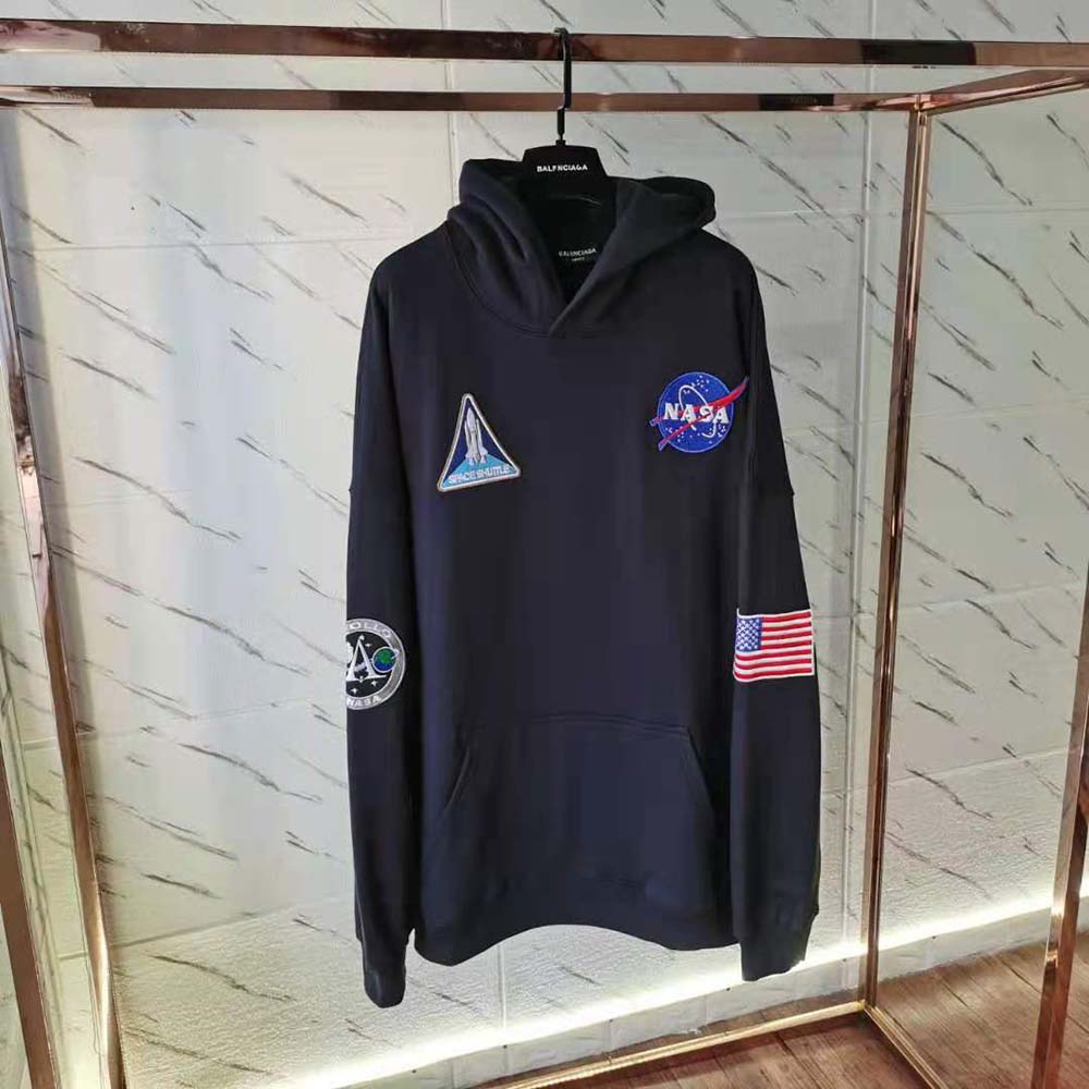Close-up showing embossed Balenciaga logo on black hoodie fleece