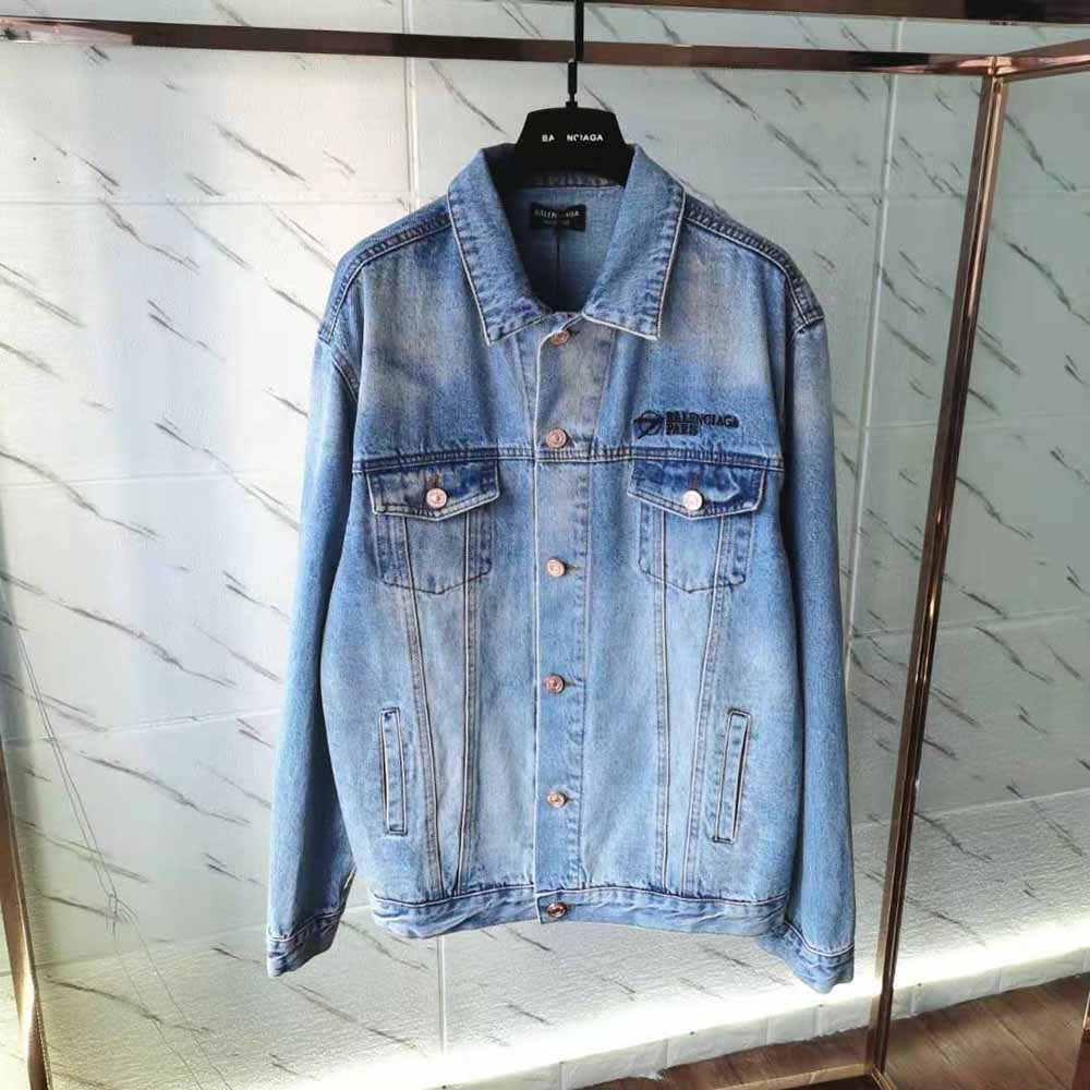 Close-up of metal Balenciaga logo buttons on indigo jacket