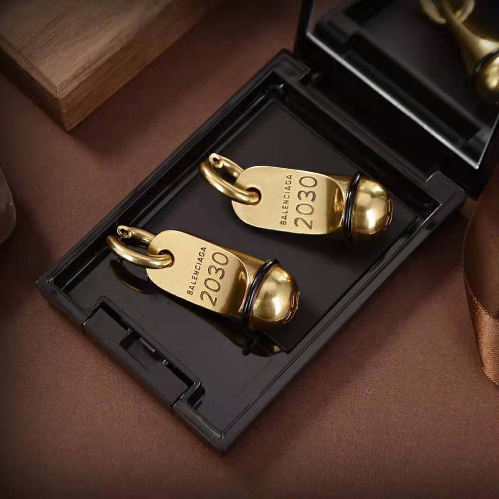 Balenciaga Women Hotel Earrings displayed against black background emphasizing gold brass finish