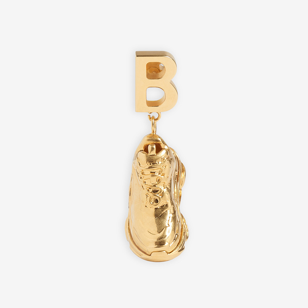 Close-up of Balenciaga Women Mini Triple S Earring in gold bronze and brass
